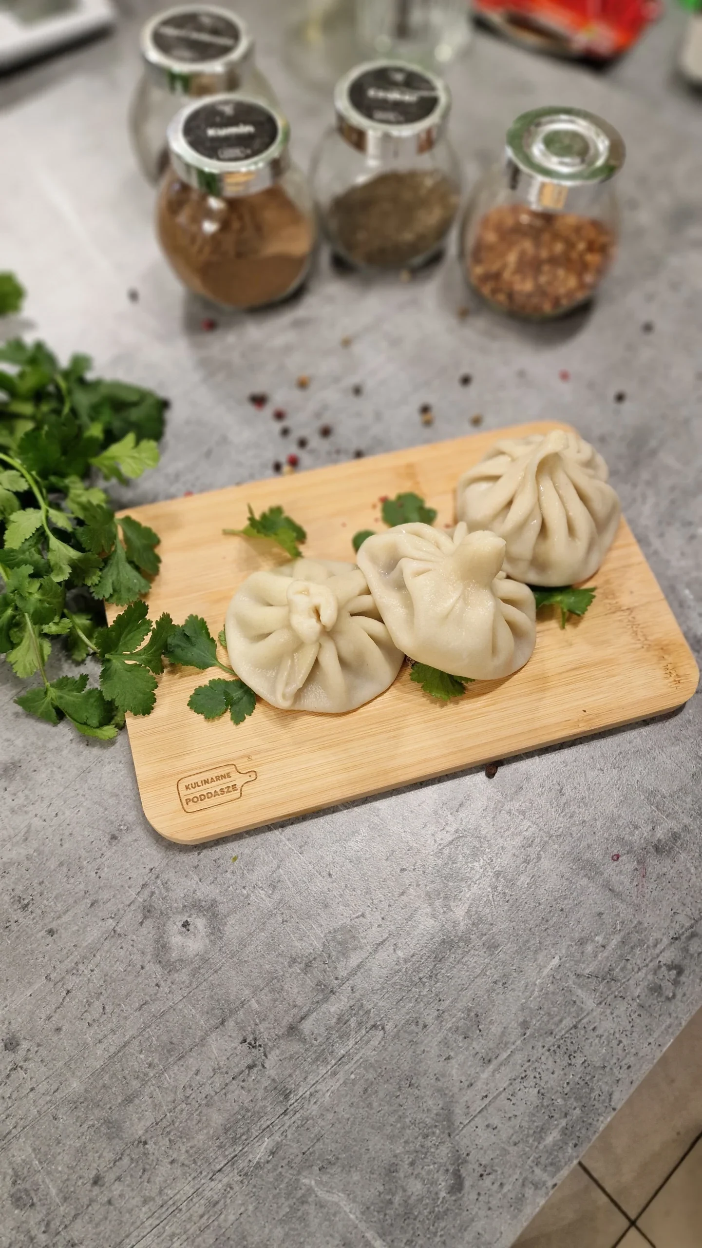 Pierożki ułożone na desce z dodatkiem ziół.